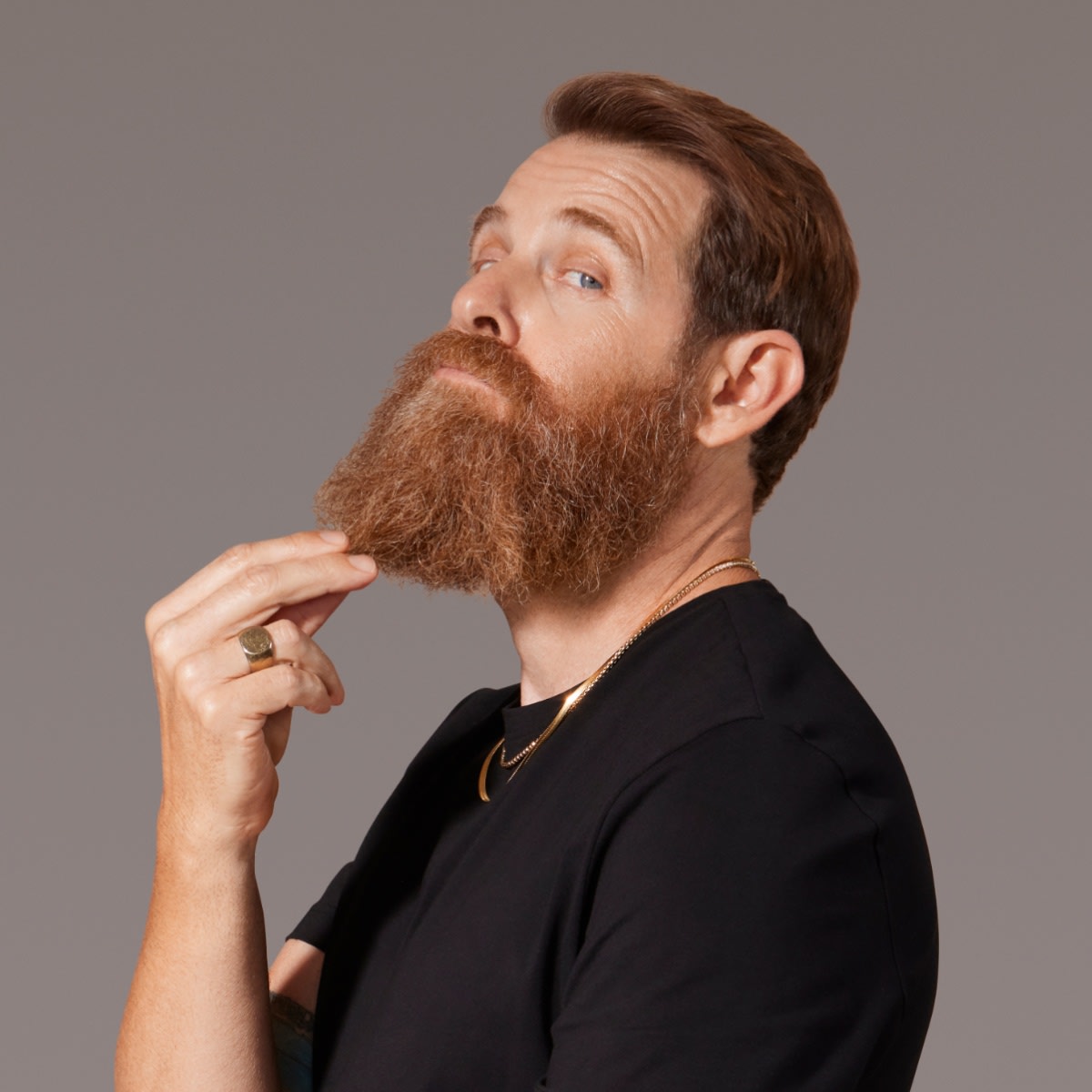 White male model scratching the tip of his large thick beard