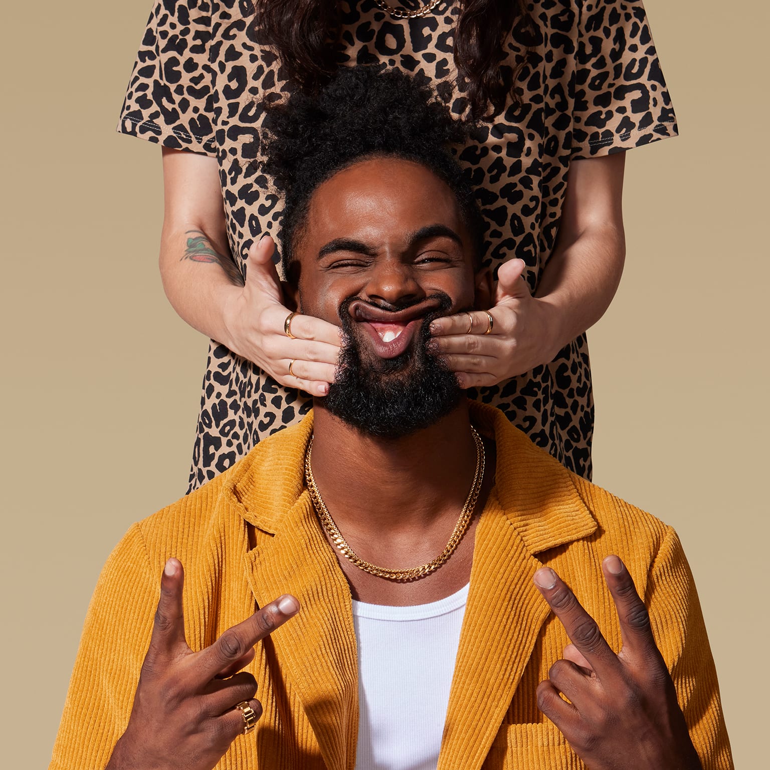Man having cheeks squished by two hands