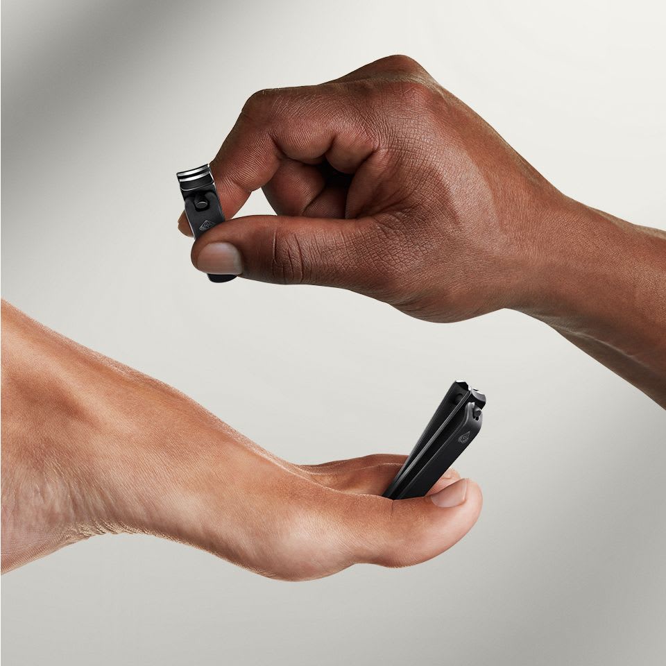 Close-up of The Shears 3.0 nail and toenail clippers being held by male models hand and foot