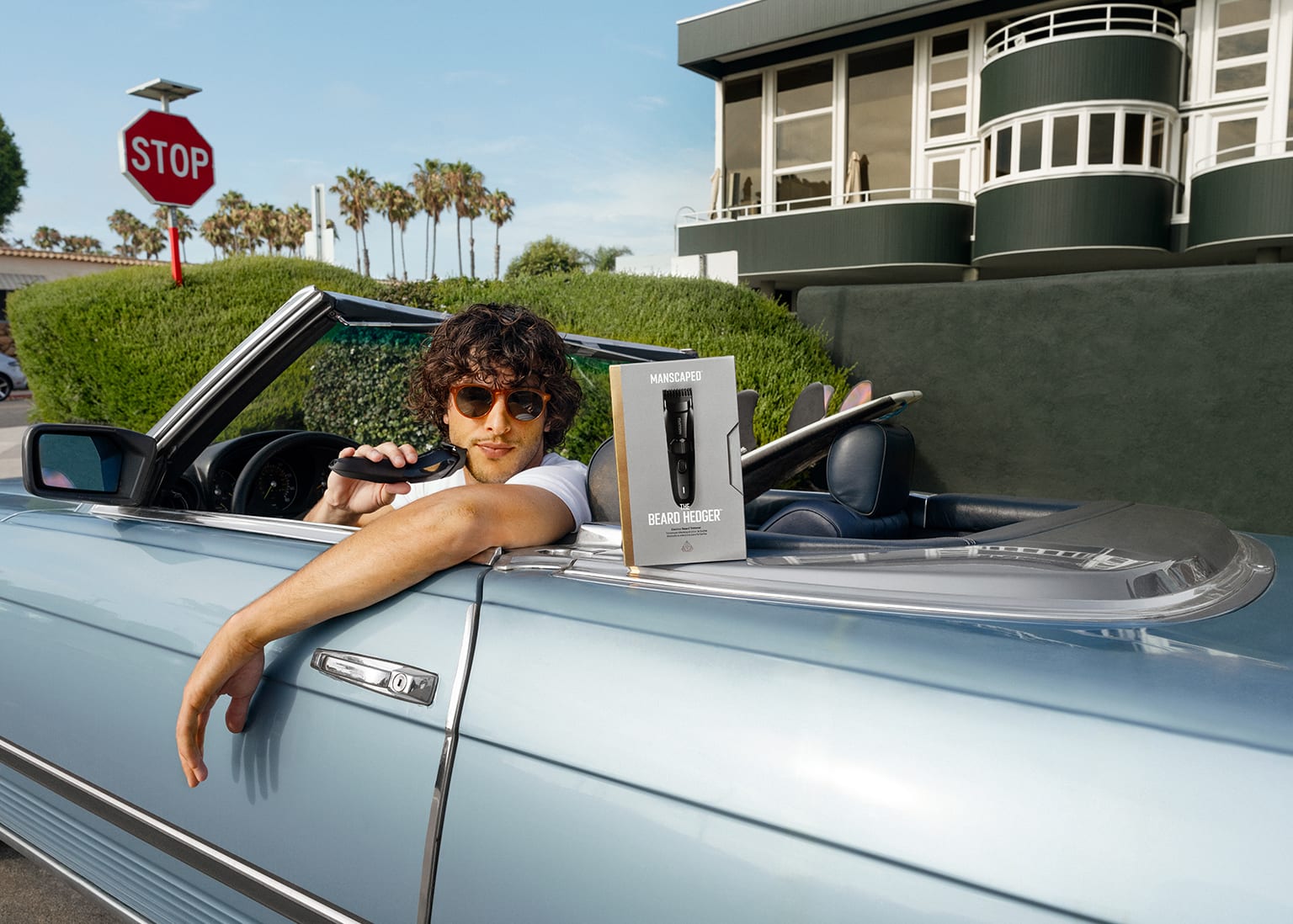Male model driving convertible while using The Beard Hedger on his beard