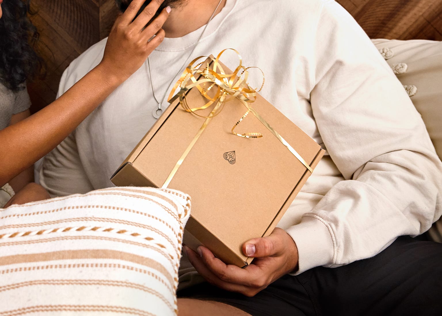 Male model holding onto MANSCAPED gift package with a female model next to him