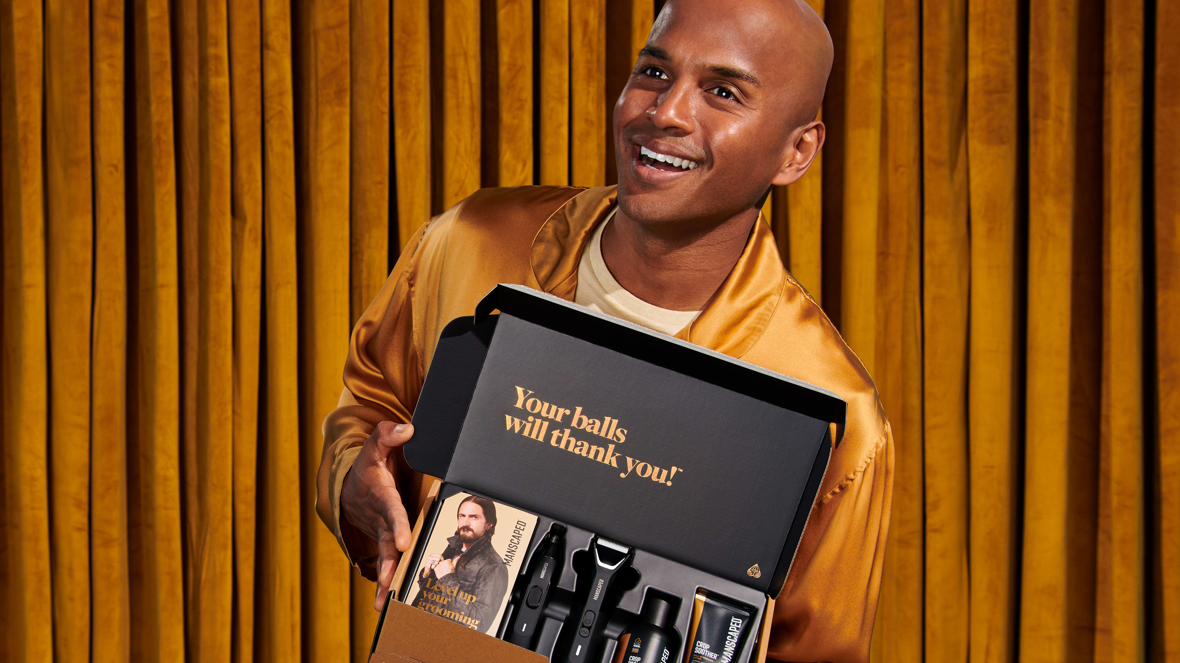 Male model in golden suit holding the Performance Package in his hands