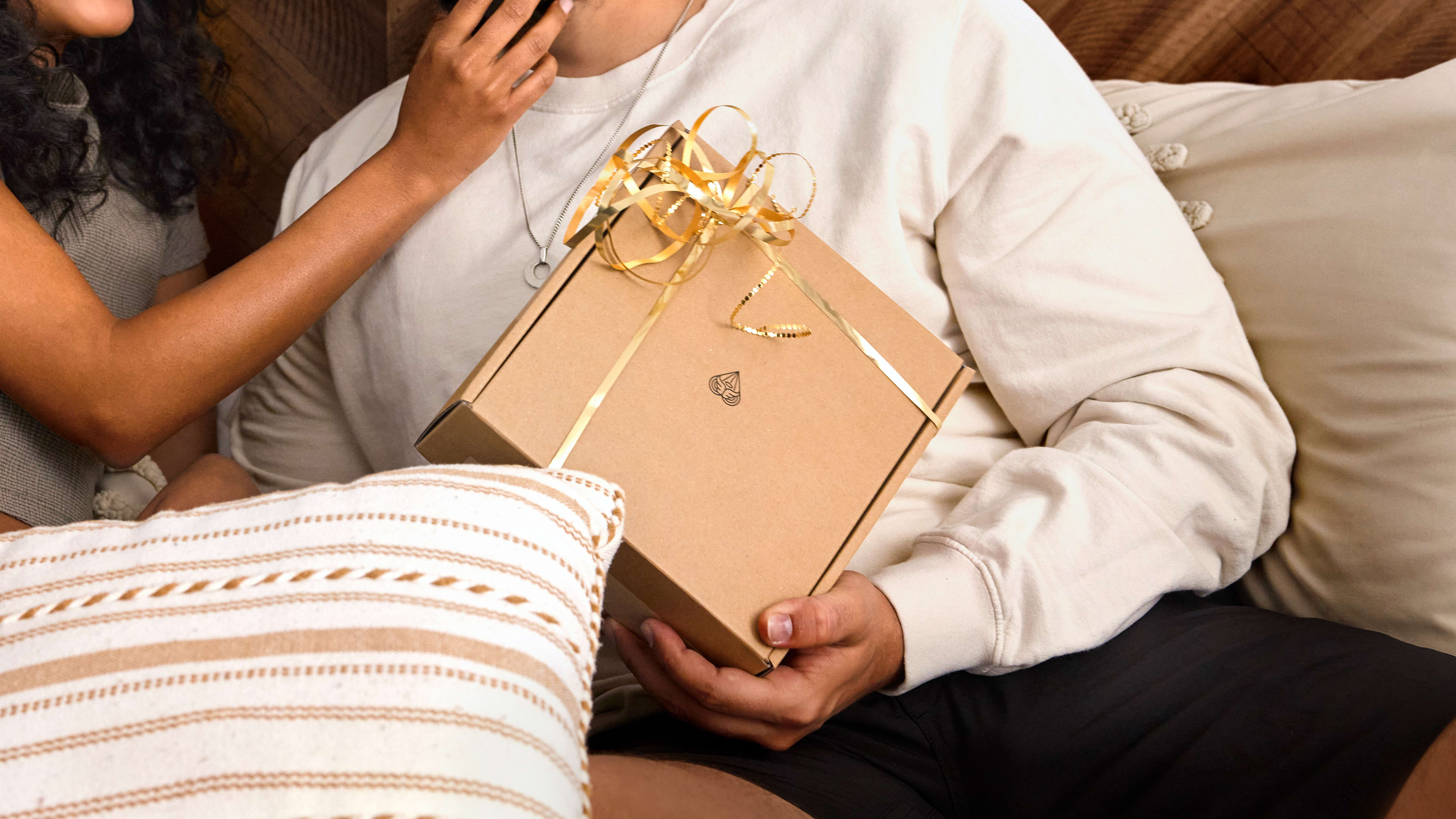 Male model holding onto MANSCAPED gift package with a female model next to him
